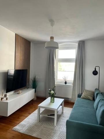 a living room with a blue couch and a tv at Cityapartment Rosi in Pasewalk