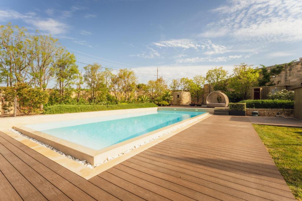 a swimming pool in a backyard with a wooden deck at New to the market - 4BR Farmhouse with Pool by SF Homes in Siġġiewi