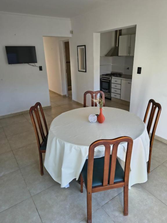 ein weißer Tisch mit Stühlen und einer Vase darauf in der Unterkunft Aloha 3 in Chacabuco
