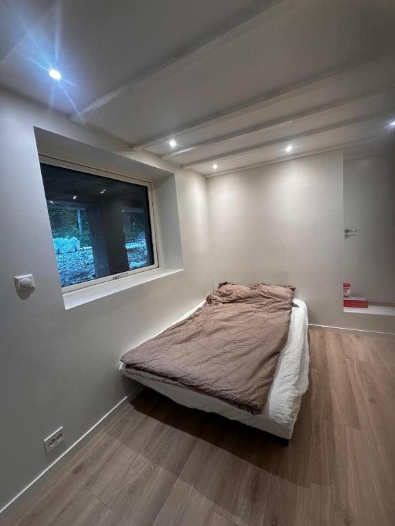 a bedroom with a bed with a window in it at Abildsø Apartment in Oslo