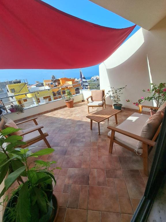 a patio with a couch and chairs on a roof at Cap Ouest Praia Guesthouse in Praia