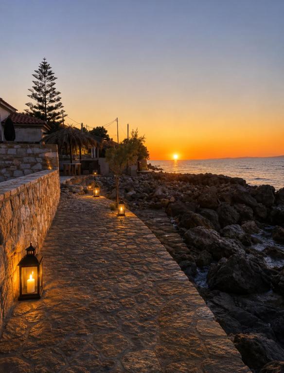 a pathway with lights on the beach at sunset at Villa Harmonia II-Seafront Retreat in Livadáki