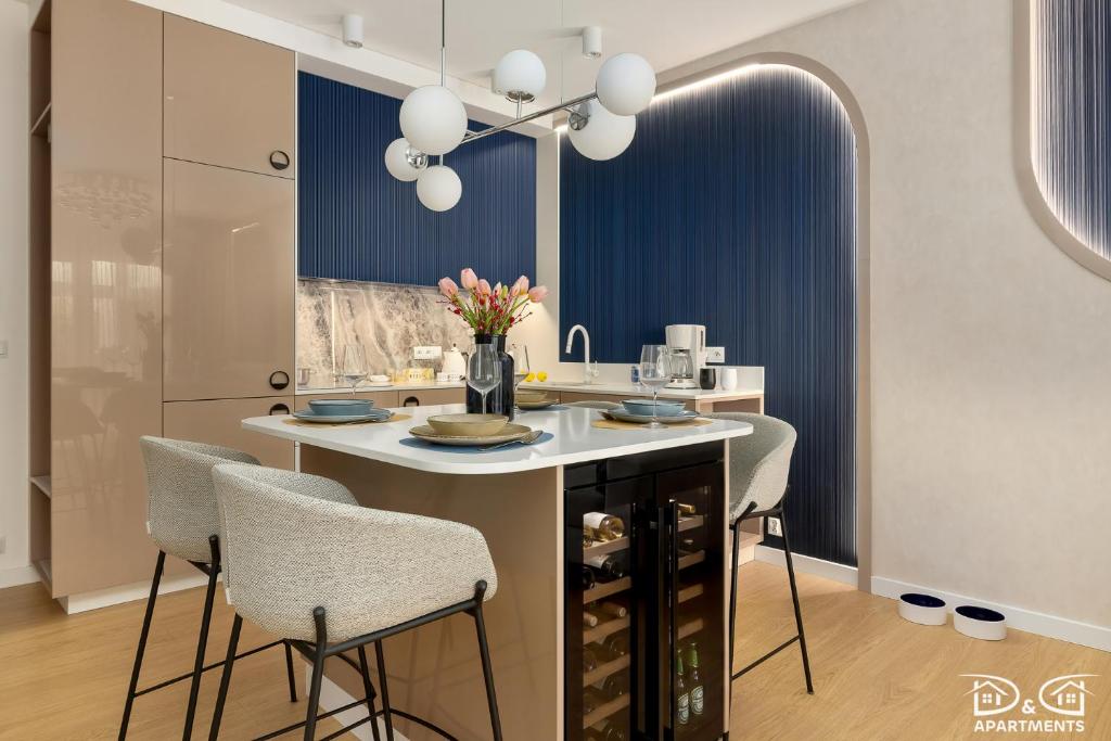 a kitchen with a island with chairs and a table at Apartament POGO LOVERS in Pogorzelica