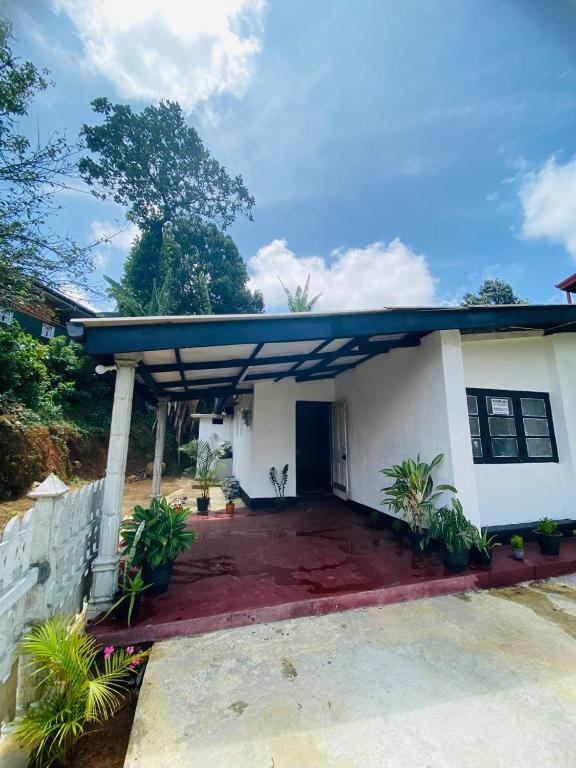 a small white house with a blue roof at Chill Bill Holiday inn in Haputale