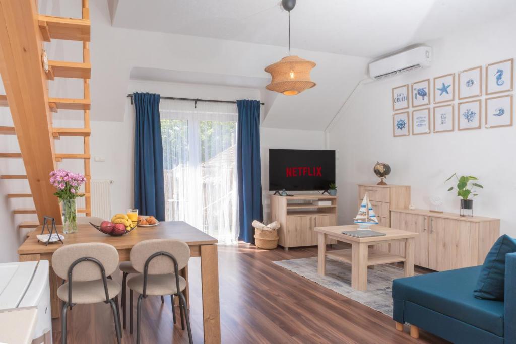 a living room with a table and a blue couch at Captain's Quarters - with Terrace and Parking near Lake Balaton in Keszthely