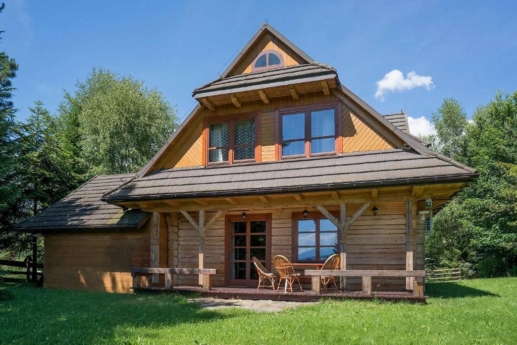 a log cabin with a gambrel roof on a field at Jaworówka na Polnej in Nowy Targ