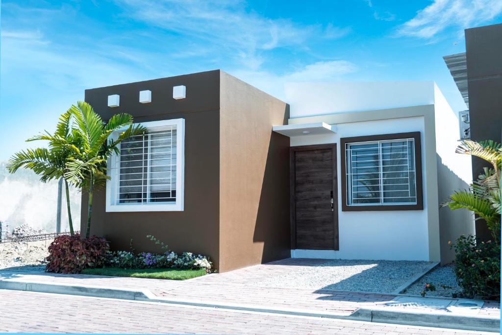 a house with a palm tree in front of it at Casa Rafaela in Santa Elena