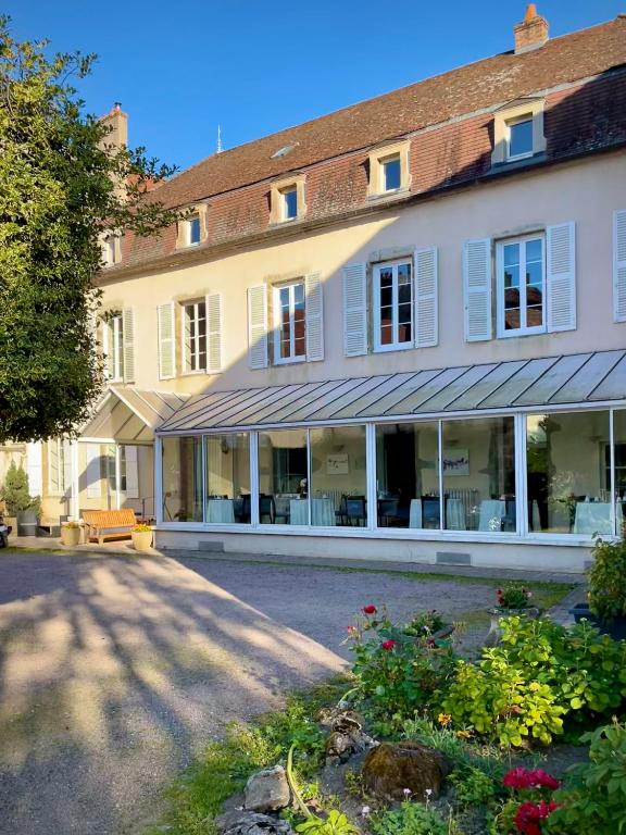 a large white building with a lot of windows at Hôtel des Cymaises in Semur-en-Auxois