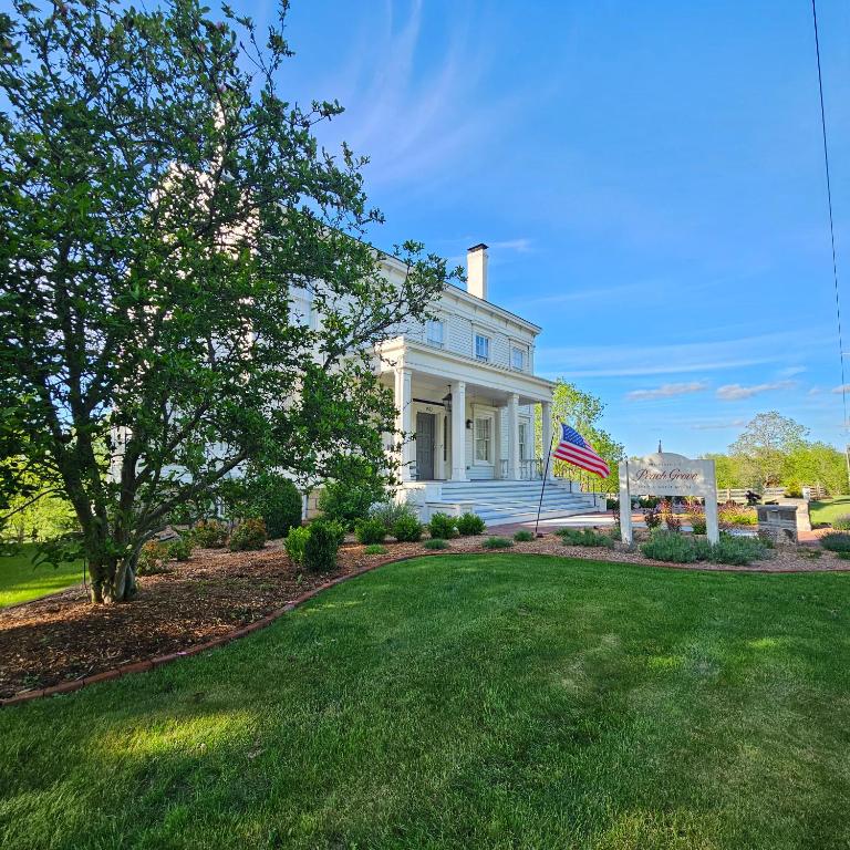 a white house with a flag on the lawn at Peach Grove House in Warwick
