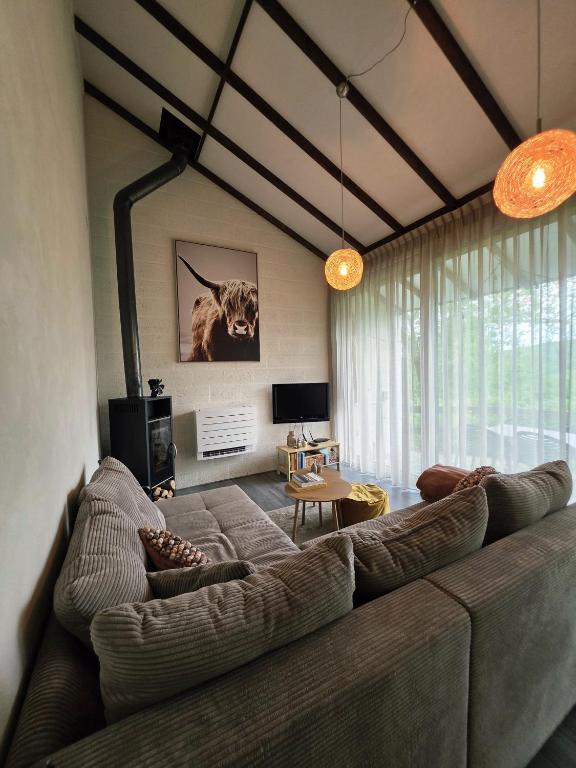 a living room with a large couch in a room at Slow Stay Coo in Stavelot