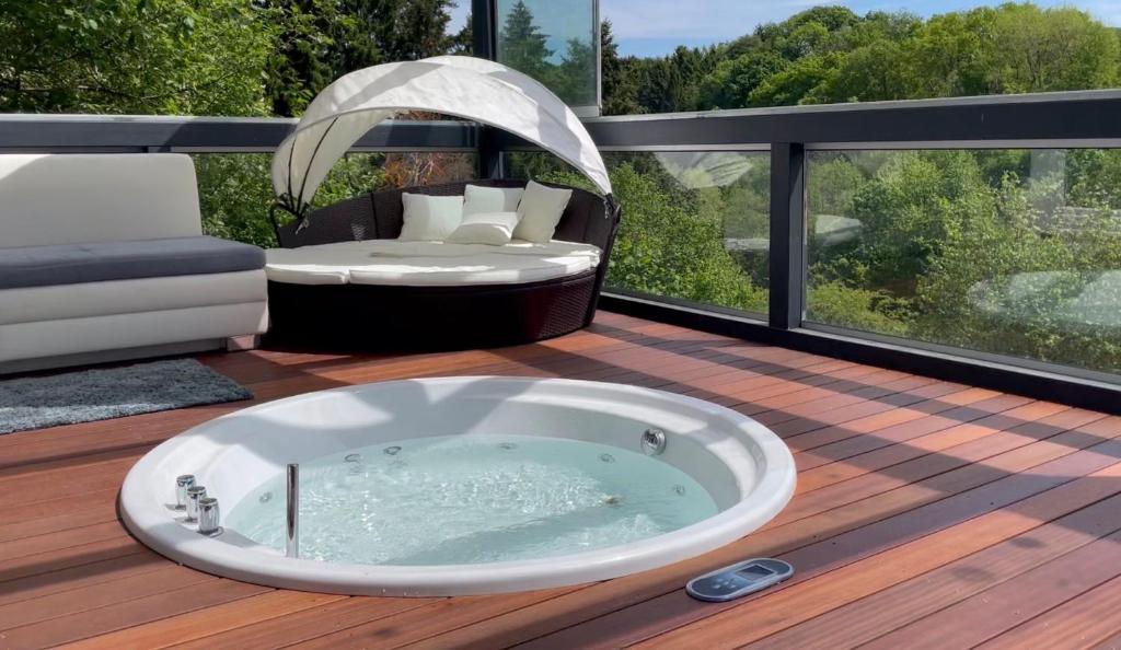 a hot tub on the deck of a house at Eifelloft&Spa in Adenau