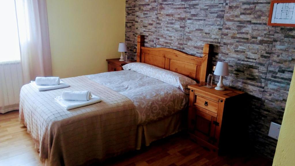 um quarto com uma cama com duas toalhas em El Pozo de la Cotarra em Cabezuela