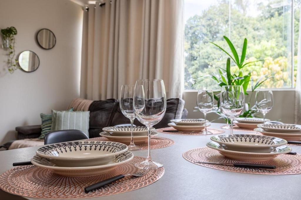 a table with plates and wine glasses on it at APT 302 - 5 min do aeroporto com ar-condicionado, rodoviária e embaixadas in Brasília