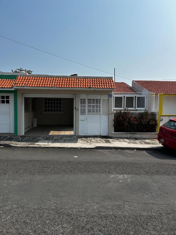 a house with a garage and a red roof at Comfortable house with an excellent location in Veracruz
