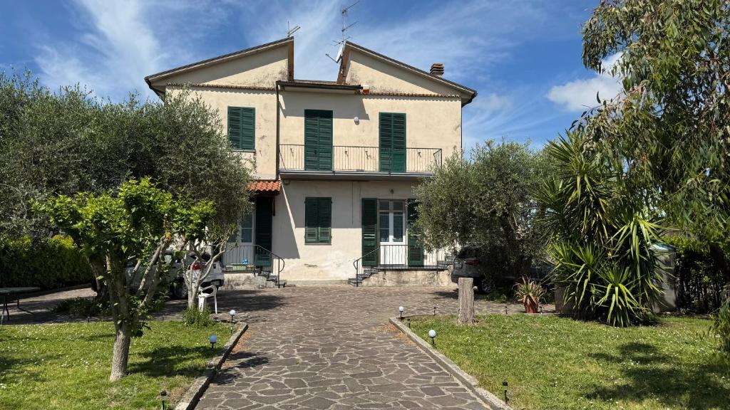 a large white house with green shutters at La Casa di Katia in Pisa
