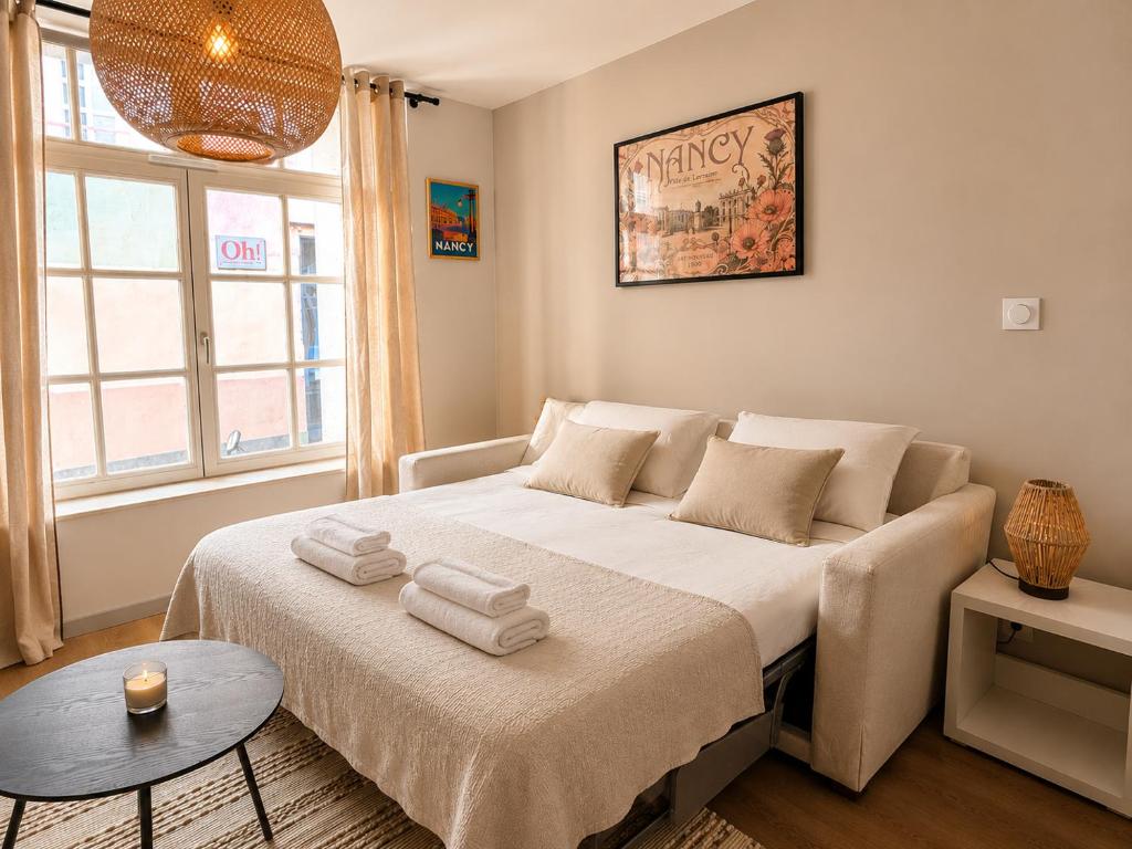 a bedroom with a large bed with towels on it at L'Instant Saint-Epvre Charm & Old Town in Nancy