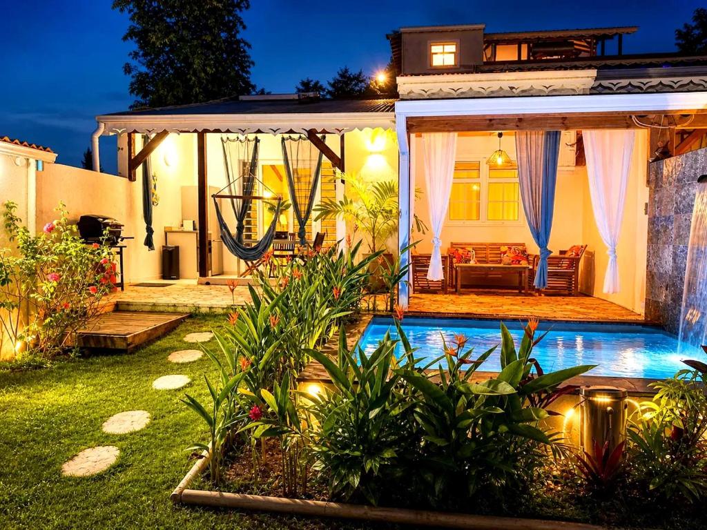 a house with a pool in the yard at night at Géko, piscine, jardin, paisible in Sainte-Luce