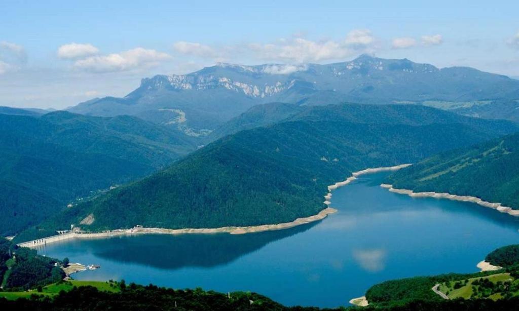 a view of a lake in the middle of mountains at Casa mica in Ceahlău
