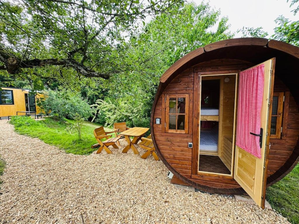 a small wooden cabin with a picnic table in a park at Schlaffass im Apfelhain in Hohenraunau