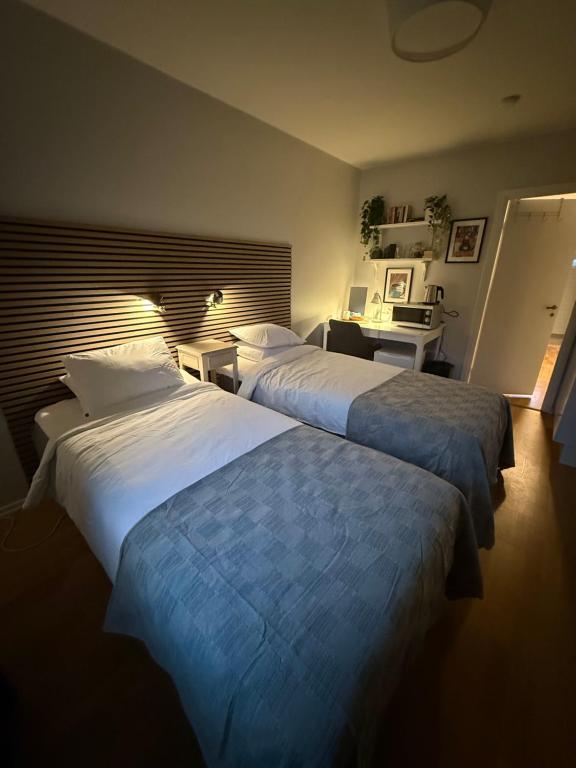 a hotel room with two beds and a desk at Morfslottet in Gothenburg