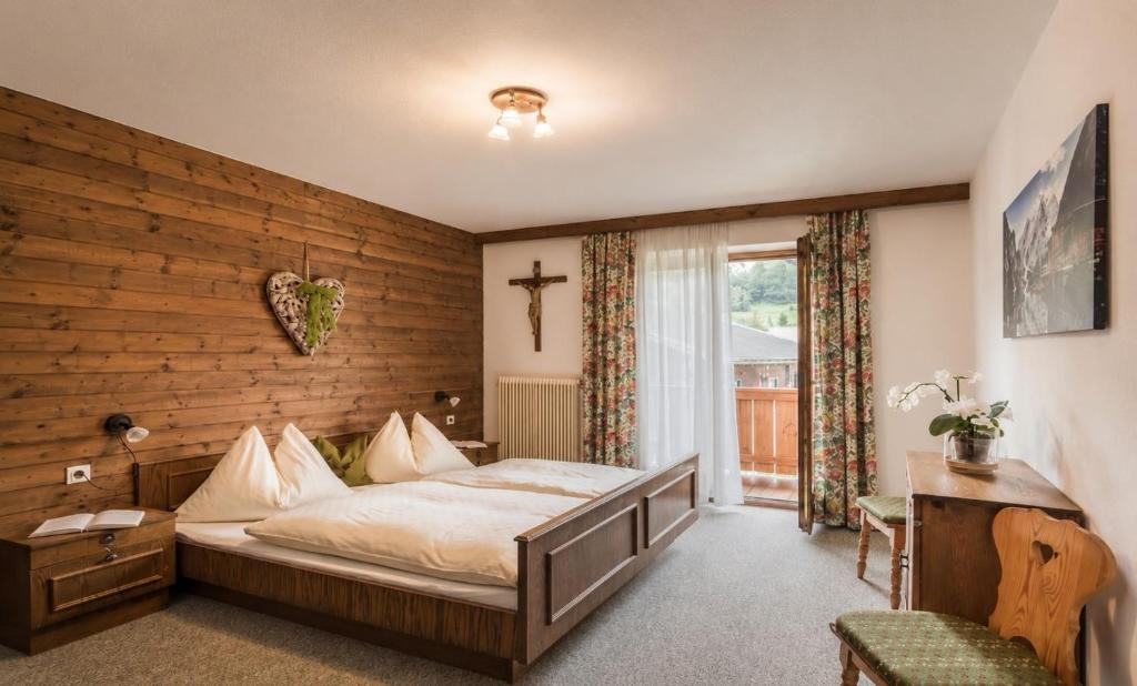 a bedroom with a bed and a wooden wall at Wolfbachgut - Ferienwohnung 1 in Taxenbach