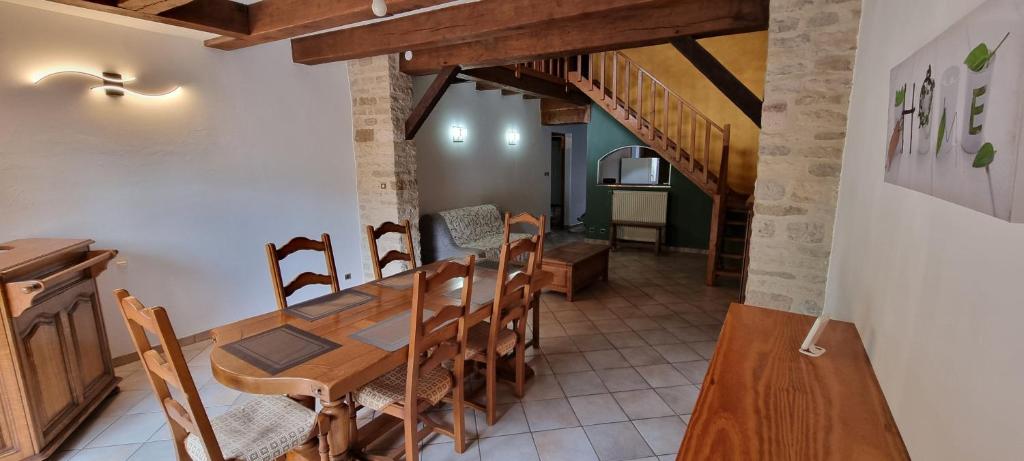 a kitchen and dining room with a wooden table and chairs at Le gîte des Sorbiers in Charmes-lès-Langres