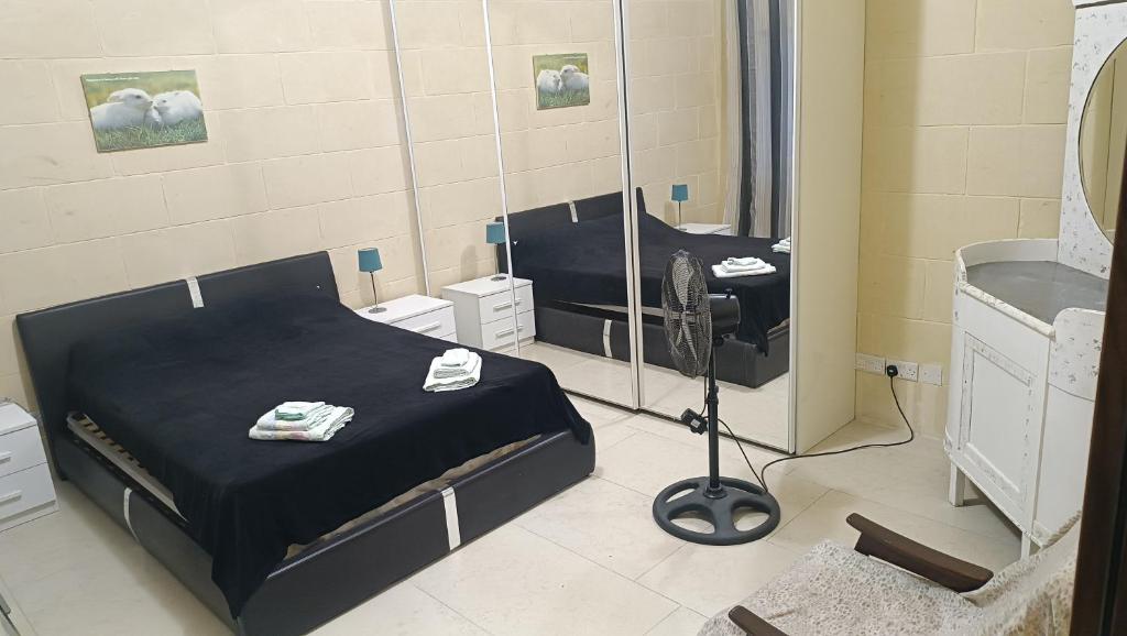 a bedroom with two beds and a mirror at Tan-Nahal Court Apartment, Sannat Gozo in Sannat
