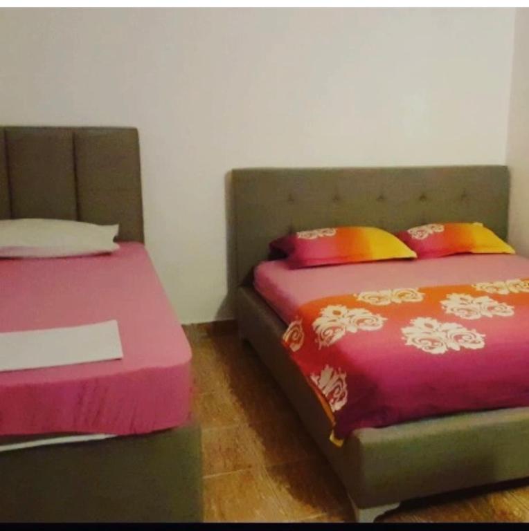 two beds sitting next to each other in a room at Apartmani Ljilja in Zgrada
