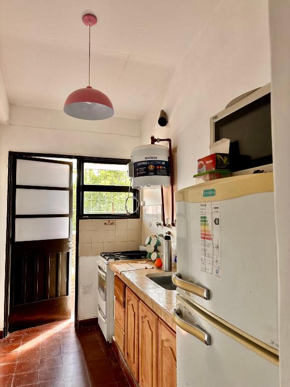 a kitchen with a white refrigerator and a sink at El Descanso APART in Libertador General San Martín