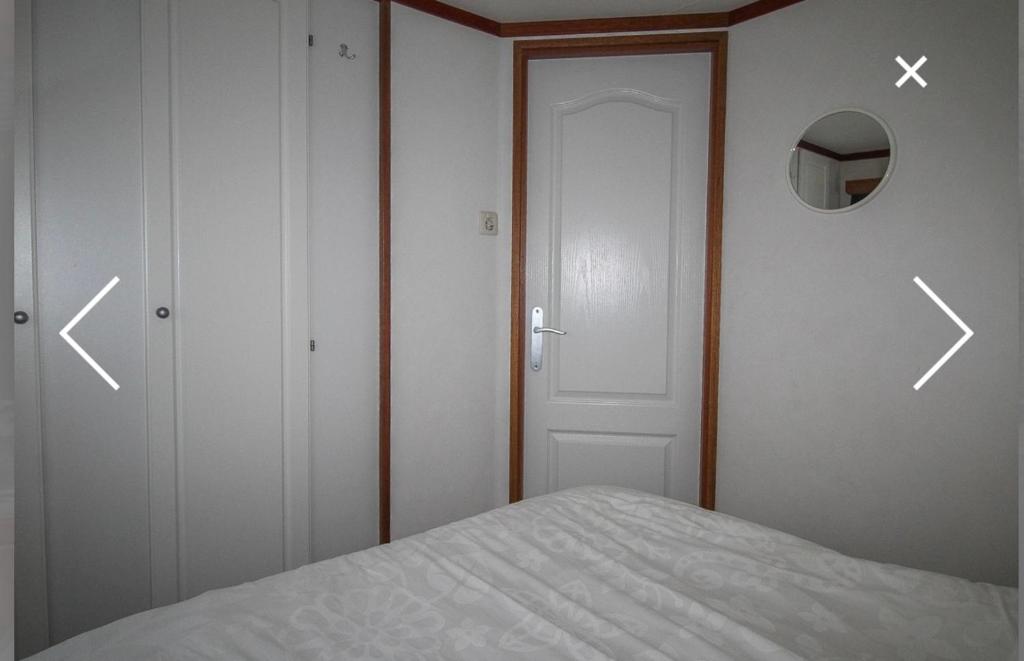 a bedroom with two doors and a bed with arrowscolm at Champagnehuisje in Voorthuizen