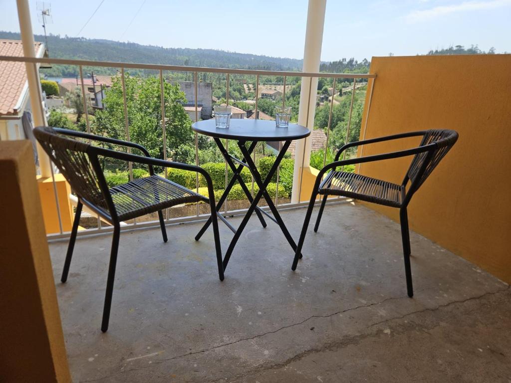 two chairs and a table on a balcony at Relaxing Riverside Escape & Stunning Sunset Views in Santa Comba Dão