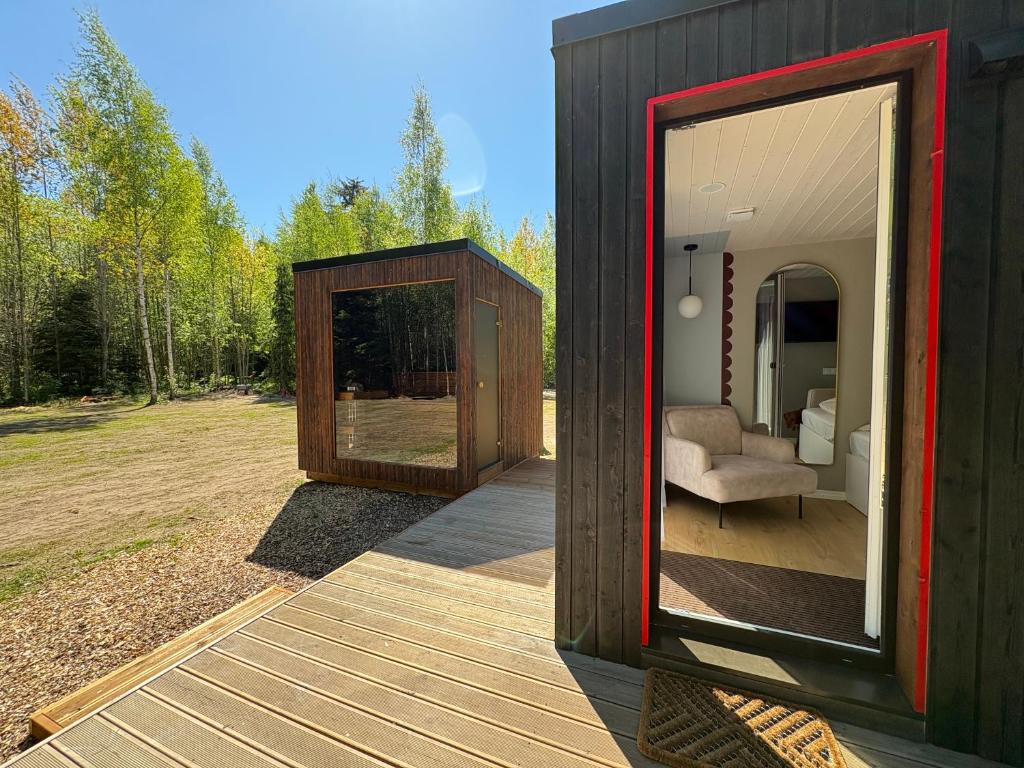a black house with a window and a couch on a deck at MetsaMaja in Hiiumaa