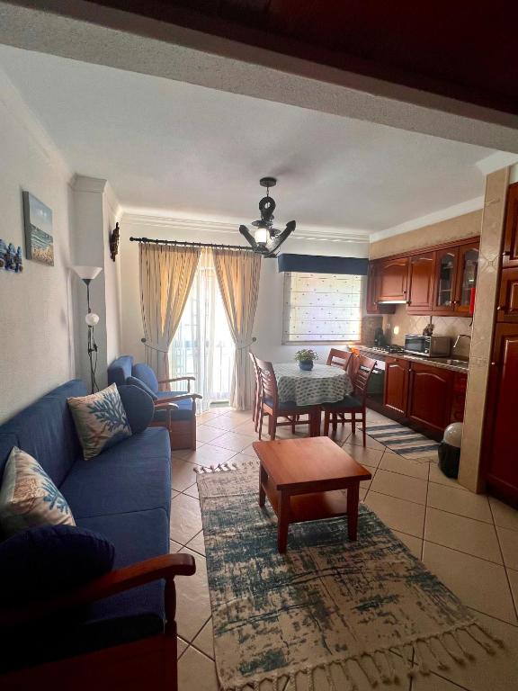 a living room with a blue couch and a table at Monte Gordo T1 - Estrela do Mar in Monte Gordo