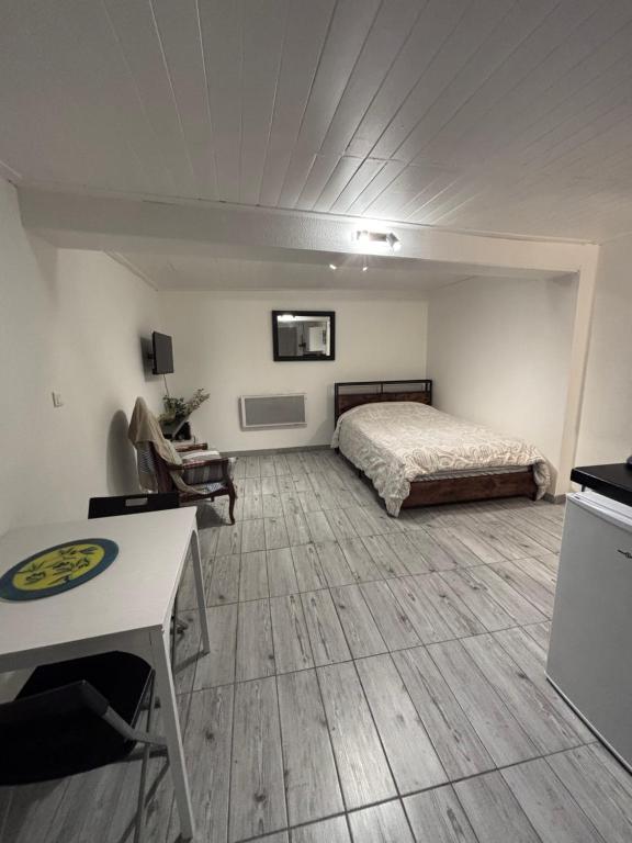 a bedroom with a bed and a desk in a room at Studio agréable et paisible in Aubagne