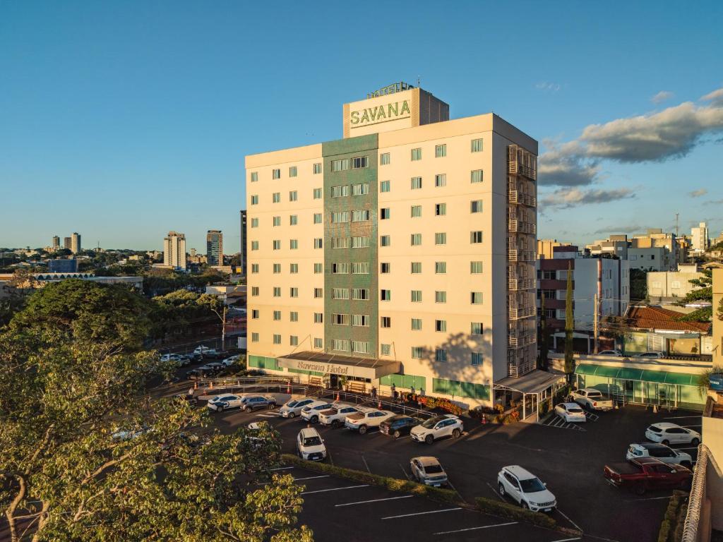 a building with cars parked in a parking lot at Savana Hotel in Uberlândia