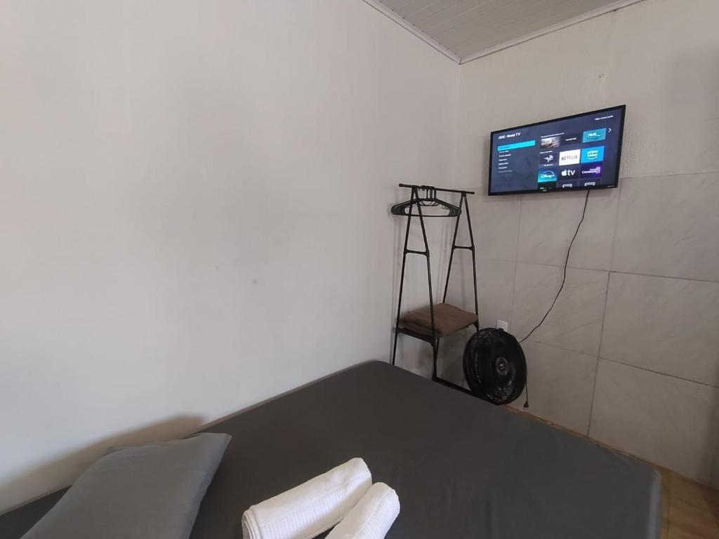 a room with a table and a tv on a wall at Casa completa - Ótimo Custo-benefício in Itajaí