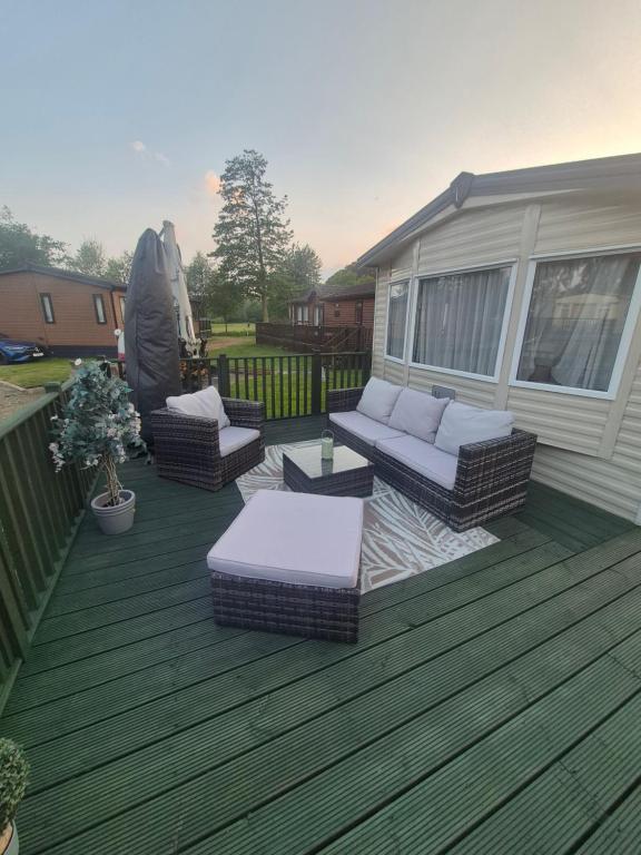 a deck with couches and chairs on a house at 89 Main Park , Lilliardsedge in Harrietsfield