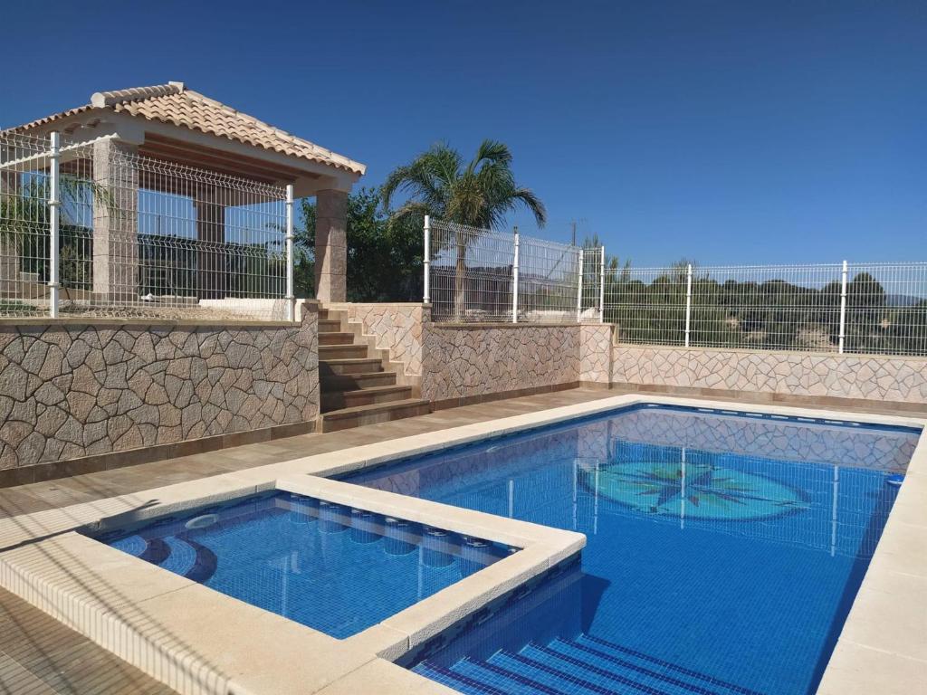 a swimming pool in a yard with a house at Casa Rural Paraje La Venta in Pliego