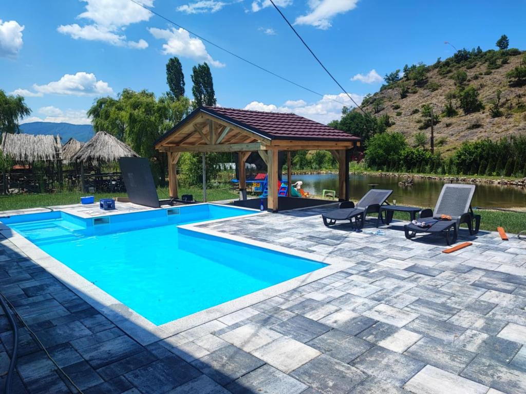 ein Pool mit einem Pavillon und Stühlen daneben in der Unterkunft Cozy "Vila Koki" with Private Pool and Lake Surrounded by Nature in Gabrovo