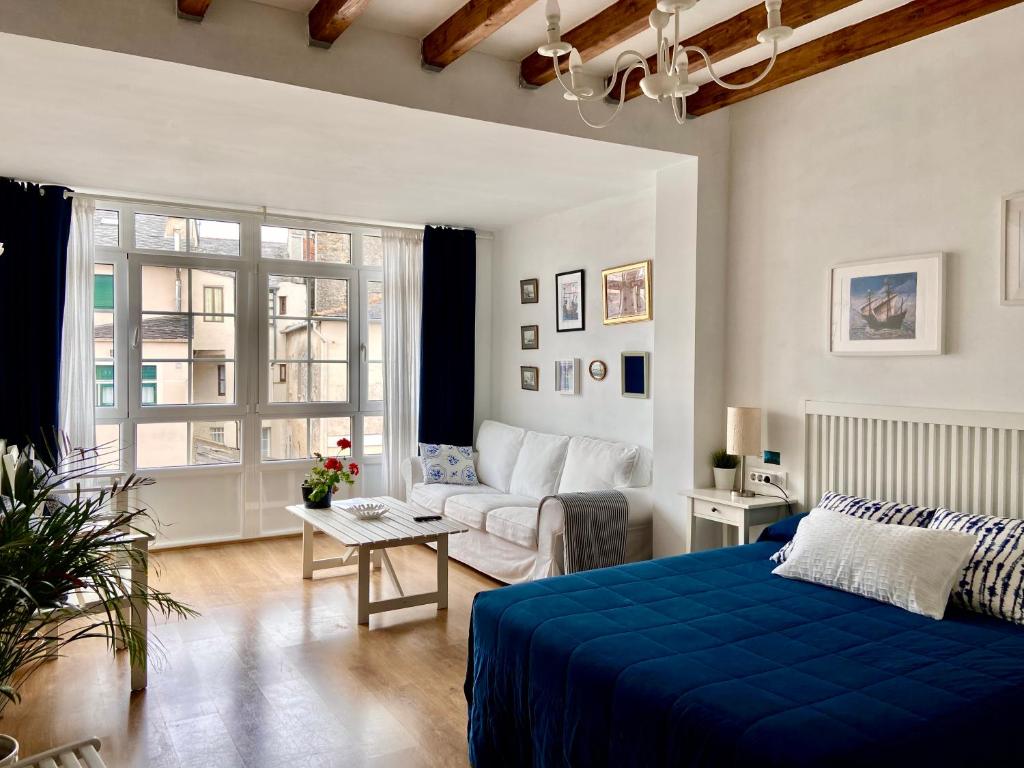a living room with a blue bed and a couch at El Galeón in Ribadeo