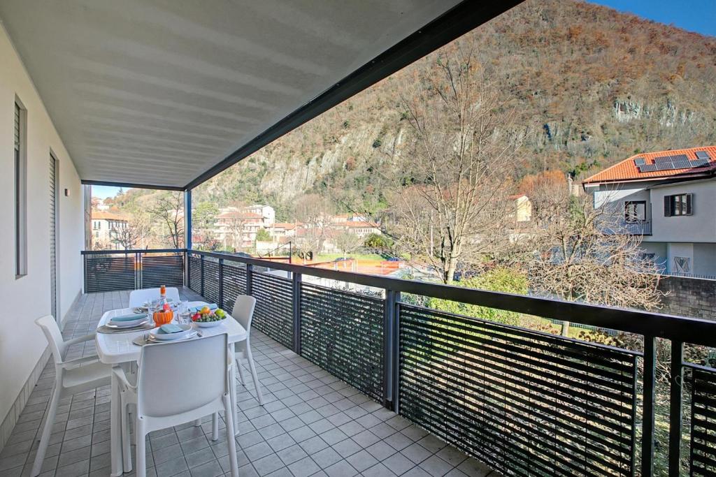 a balcony with a table and chairs and a view at Magnolia: Laveno Centre 2BR with Terrace - Happy Rentals in Laveno-Mombello