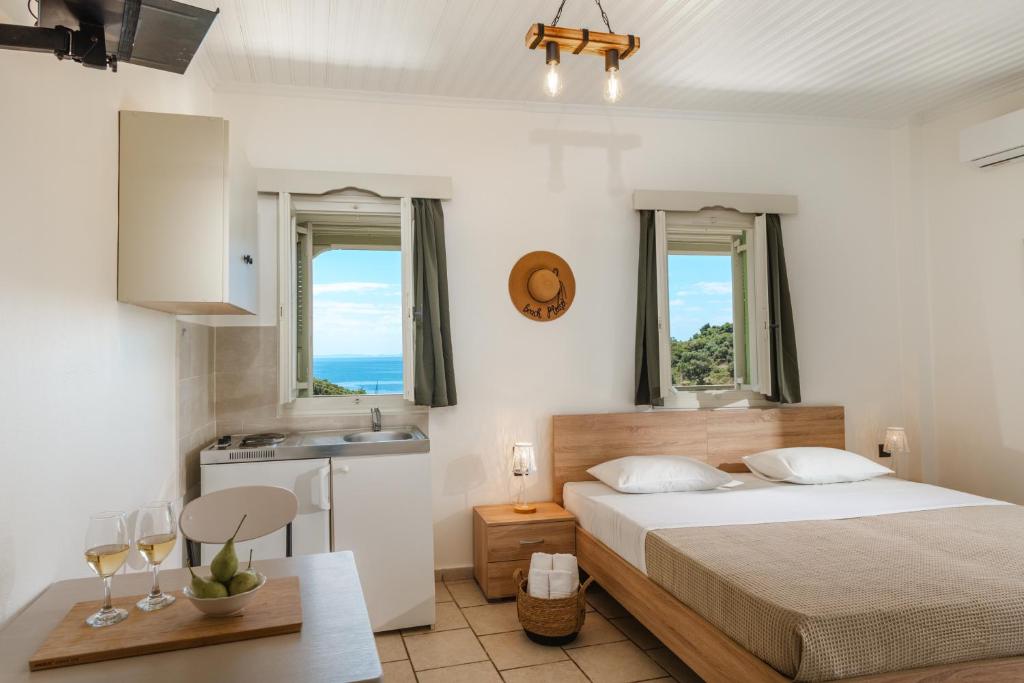 a bedroom with a bed and a sink and two windows at Amorosa Nest - Adults Only by Eutopia in Syvota