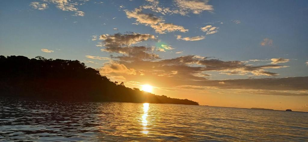 a sunset over a body of water with a mountain at Drake Lapas in Drake