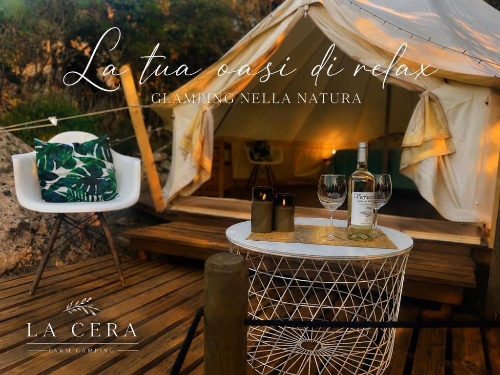 a tent with two glasses of wine on a table at La Cera Farm Camping B&B in Santa Teresa Gallura