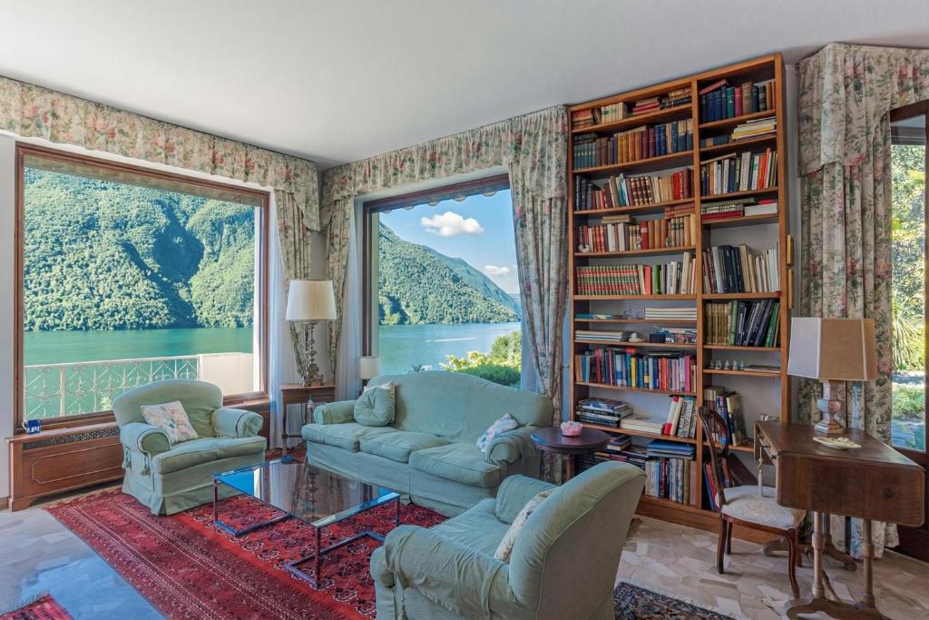 a living room with two couches and a large window at Il Tentione in Valsolda