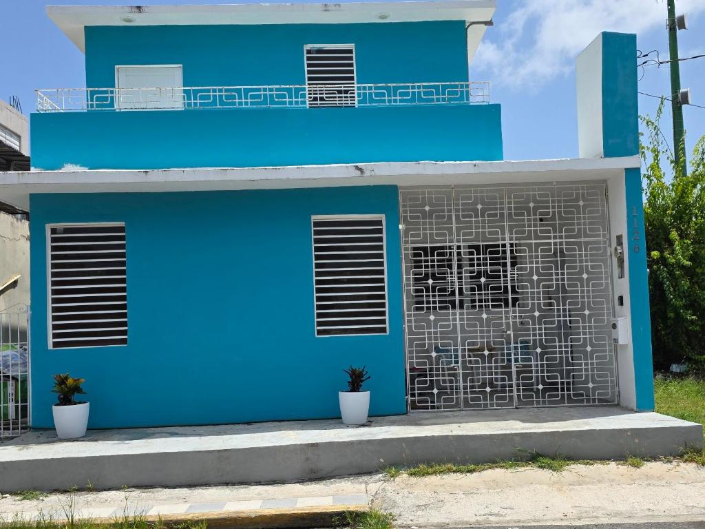 a blue house with two windows and a balcony at La Casita de Ceiba in Ceiba