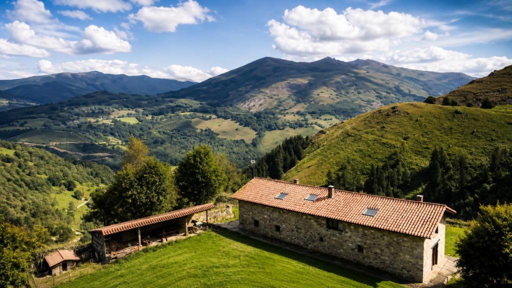 a house on a hill with mountains in the background at Laguna de Valfría in Fresneda