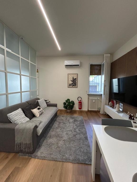a living room with a couch and a tv at Corona dei Sogni Appartamento moderno vicino Ospedale e Centro in Novara