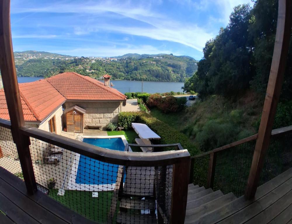 a view from the balcony of a house with a swimming pool at Private Pool Douro River View Villa in Baião