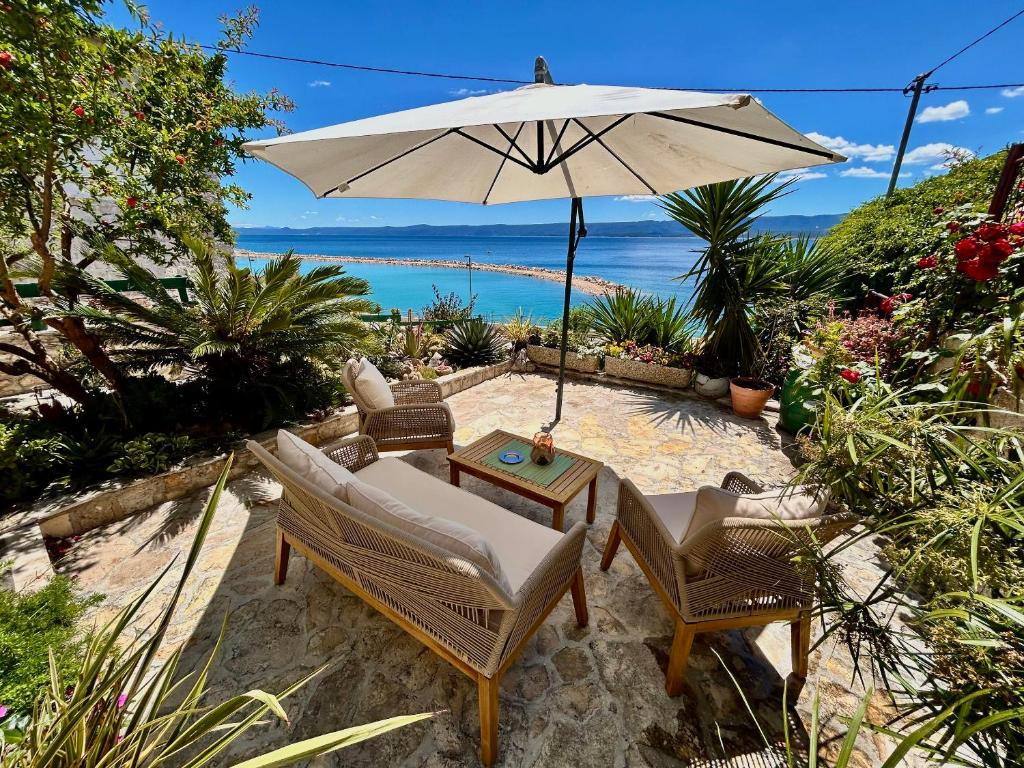 a patio with a table and chairs and an umbrella at Apartments Matea in Bol